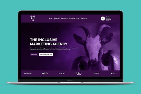 A laptop displaying purple goats website homepage.