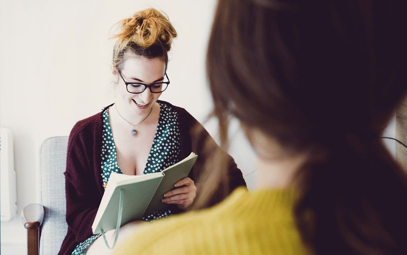 Woman writing in notebook while considering decision